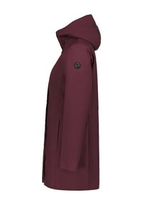 Chaqueta impermeable color marrón con capucha, que presenta un logo negro en la manga, bolsillos laterales y un diseño de corte recto.