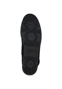 Semelle de chaussure en caoutchouc noir avec un motif hexagonal texturé, zones contrastantes de surfaces lisses et striées, dotée d'un talon circulaire.