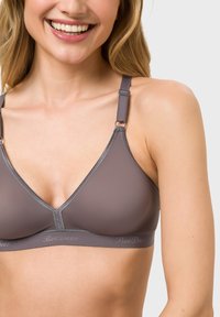 Dark gray triangular bra with adjustable straps, featuring a smooth texture and a soft band with the brand name subtly printed.
