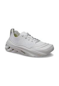 White athletic shoes with a textured fabric upper, cushioned sole, and rounded toe. Features a lace-up design and a rear pull tab.