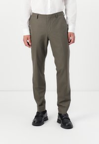 Khaki tailored trousers made of smooth fabric, featuring a slim fit, side pockets, and a clean, straight-leg design. Paired with black shoes.