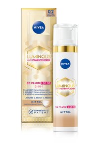 NIVEA Luminous CC Fluid in medium shade, white and gold cylindrical bottle with pump dispenser, packaged in a matching box featuring hexagonal patterns.