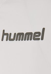 Witte stof met een opvallende zwarte opdruk van het woord "hummel", met een gladde textuur en een modern, rond lettertype.