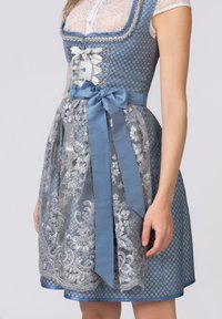 Traditional dirndl with blue patterned bodice, lace overlay, and silver floral embroidery. Features a satin bow and sheer apron.