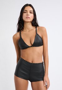 Top bikini in faux leather nero con coppe triangolari e dettagli con borchie, abbinato a slip a vita alta con borchie simili lungo l'elastico in vita.