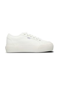 White low-top sneaker with textured upper, lace-up closure, platform sole, and small side tag on a plain white background.