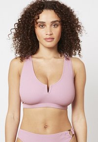 Haut de bikini rose clair à côtes avec un décolleté en V et des bretelles larges. Le tissu a une finition texturée pour un ajustement confortable.