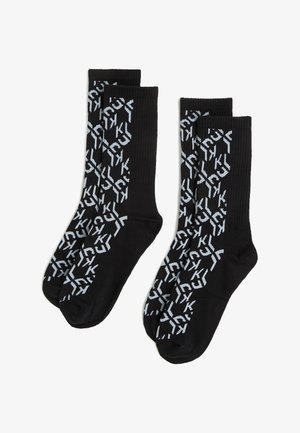 Calcetines negros de longitud de tripulación con un patrón geométrico repetido en azul claro. El material es acanalado para ofrecer textura, proporcionando un ajuste ceñido.