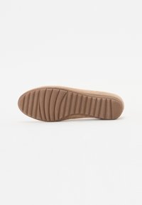 Suola in gomma marrone con scanalature orizzontali per trazione e supporto. Texture liscia, forma leggermente curvata.