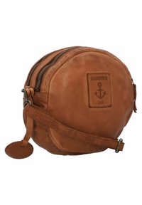 Borsa rotonda in pelle marrone con due cerniere, una tracolla removibile e un logo a forma di ancora in rilievo. Presenta una superficie texturizzata e un tag decorativo appeso.