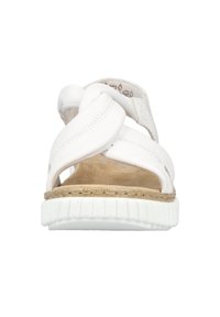 White leather sandal featuring crossed straps, a beige suede insole, and a textured white rubber sole. Minimalist design with no embellishments.