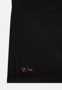 Juodas audinys, fokusuojantis į detalę, su elegantišku dizainu, subtiliu blizgesiu ir akcentuotu bronziniu logotipu "10K" apatinėje dešinėje kampe.