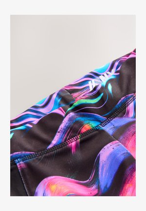 Tissu synthétique multicolore présentant des motifs tourbillonnants en rose, bleu et vert sur un fond noir ; avec un détail de logo visible.