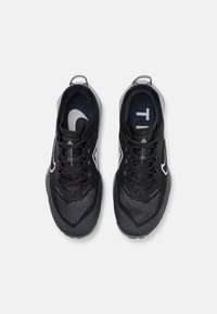 Zwarte sportieve schoenen met een gestructureerde, geventileerde bovenkant van mesh, een stevig ontwerp en een rubberen zool met een uitgesproken profiel.