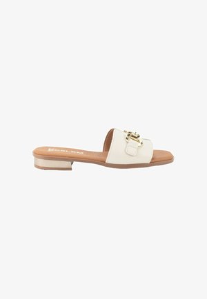 Sandalia plana tipo slide para mujer con puntera abierta en beige, con una correa ancha y detalle de hebilla dorada sobre una plantilla marrón claro y tacón metálico bajo.