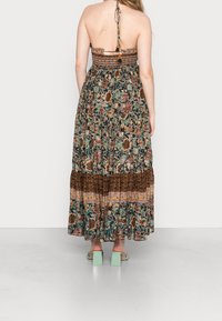 Maxi sukienka w kwiatowy wzór, wielokolorowy materiał, marszczony gorset, z detalem wiązania na plecach oraz warstwową spódnicą. Połączona z miętowymi butami na słupku.