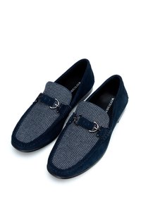 Granatowe loafersy z teksturowanym szarym wzorem w houndstooth, wykonane z zamszu, ozdobione srebrnymi detalami i przeszyciami.