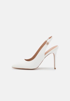 Hvid højhælet slingback sko med spids tå og lille dekorativ spænde med perler på remmen mod hvid baggrund.