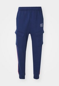 Marina blå Nike Air sweatpants med elastisk midja, sidofickor, nederdelar med muddar och röd randdetalj längs benen.
