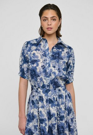 Blomsterprintet kjole med blå og hvide farver, knappet krave, korte ærmer og en taljeret linning med et flydende skørt.