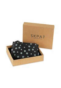 Funda negra con cremallera con un patrón de margaritas, hecha de un material texturizado, colocada en una caja de cartón marrón con la marca "SKPAT".