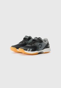 Chaussures de sport noires et grises avec une tige en mesh respirant, semelle en caoutchouc avec des accents orange, et sangle réglable pour un ajustement sécurisé.