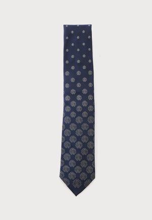 Cravate bleu marine avec un motif de cercles argentés et de motifs floraux abstraits, répartis régulièrement sur toute sa longueur.