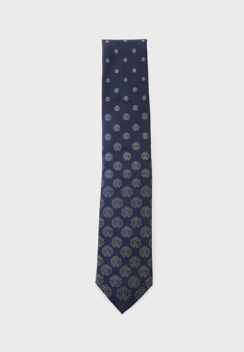 Cravate bleu marine avec un motif de cercles argentés et de motifs floraux abstraits, répartis régulièrement sur toute sa longueur.