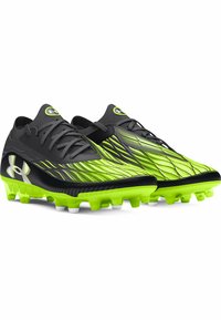 Scarpette da calcio nere e verde brillante con un design dinamico, parte superiore testurizzata e tacchetti modellati per la trazione. Logo Under Armour ben in evidenza.