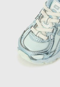 Lys blå treningssko med nettmateriale og reflekterende detaljer, med hvite lisser, polstret tunge og strukturert såle.