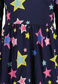 Abito navy con gonna arricciata, decorato con stelle multicolori in rosa, giallo, blu e turchese. Materiale morbido in cotone.
