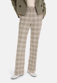 Gray and beige plaid trousers with a straight leg design, featuring a smooth texture and a concealed waistband, paired with white flat shoes.