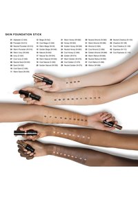 Des bâtons de fond de teint présentés sur plusieurs bras de teintes de peau variées. Chaque bâton est noir avec des accents en or rose, étiquetés par des numéros de teinte.