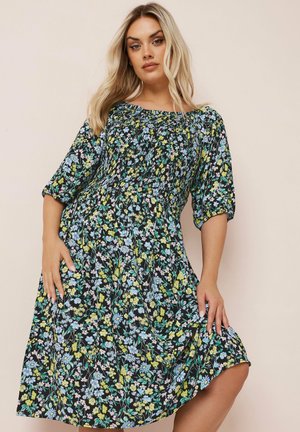 Blumenkleid mit schwarzem Grund, das ein Muster aus blauen und gelben Blumen zeigt, mit kurzen Ärmeln, einem lockeren Schnitt und einem gerafften Oberteil.