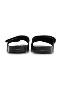 Black sandals with a flat sole and open back. Features wide straps across the top and textured footbed for comfort.