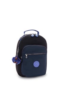 Petit sac à dos noir et marine avec une poche avant, fermetures éclair, poigné en haut et porte-clés en forme de singe en peluche bleue attaché à la fermeture éclair latérale.