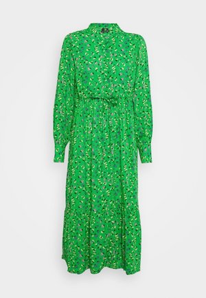 Robe midi verte à manches longues avec petit imprimé floral, col montant, taille froncée avec lien et jupe à volants sur fond blanc.