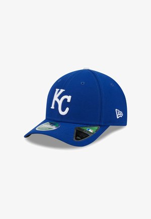 Cappellino da baseball blu in tessuto con logo bianco "KC" sul fronte, caratterizzato da una visiera curva e fori di ventilazione.