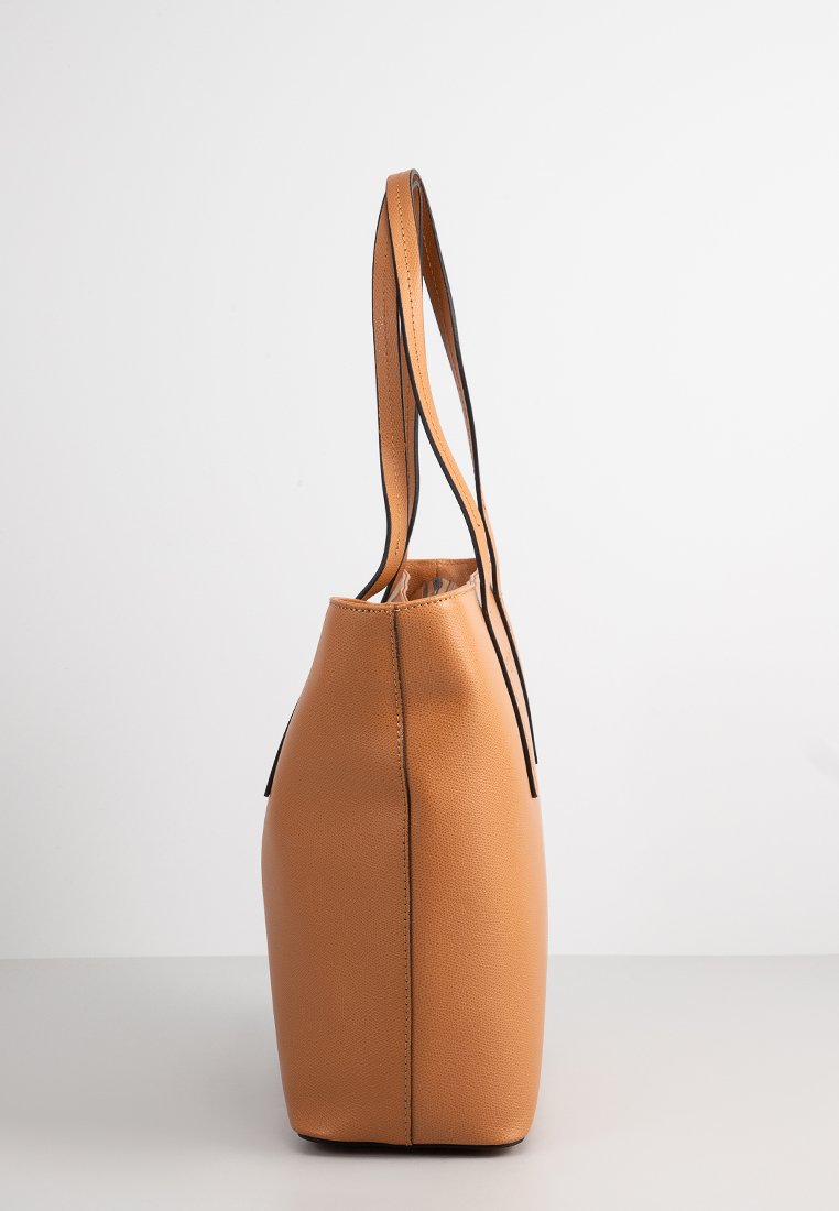 Borsa a tracolla in pelle color tan con un design strutturato, cuciture nere e due manici lunghi. Texture liscia e forma allungata.