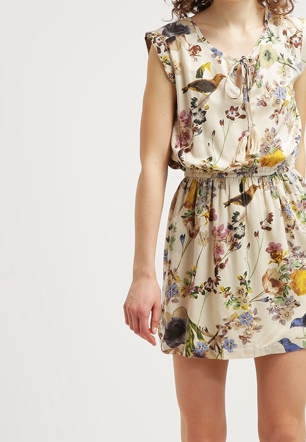 Robe à imprimé floral en tissu beige clair, avec manches courtes volantées, encolure à lien coulissant et taille élastique, ornée de motifs colorés de fleurs et d'oiseaux.