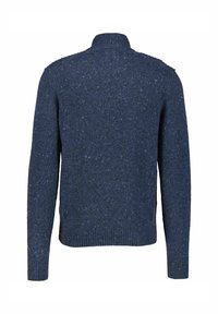 Marineblauer Pullover aus strukturiertem Strickstoff, mit hohem Kragen und gerippten Bündchen, die kleine Farbflecken für visuelles Interesse aufweisen.