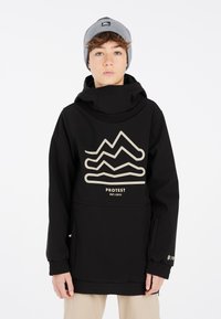 Schwarze Kapuzenjacke mit einem beigen Bergmotiv und dem Text "PROTEST". Verfügt über elastische Bündchen und eine Fronttasche. Getragen mit einer grauen Mütze.
