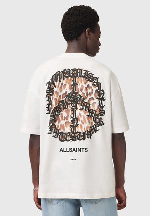 Hvid oversized t-shirt med et leopardmønstret fredstegn-design og sort tekst på bagsiden. Casual pasform og korte ærmer.
