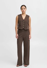 Gilet rayé marron et crème avec un décolleté en V profond et cinq boutons, associé à un pantalon large assorti. Tissu lisse, design structuré.