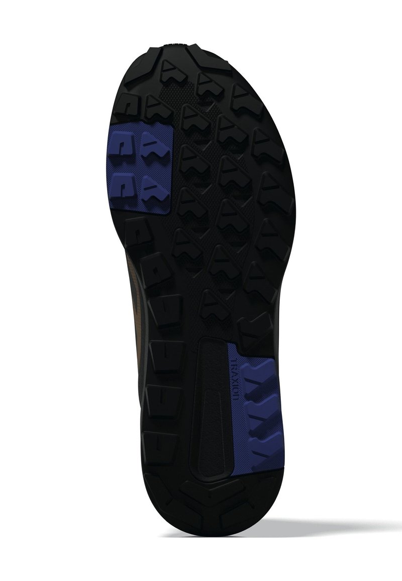 Suola di un scarpa con gomma nera robusta e accento blu, modelli di trazione distintivi e solide protuberanze geometriche.
