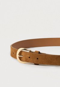 Ζώνη από καφέ σουέντ με χρυσή μεταλλική αγκράφα, διαθέτει λείο φινίρισμα, ραμμένες άκρες και πολλαπλές τρύπες για ρύθμιση του μεγέθους.