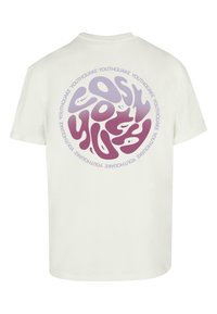 Baltas kokvilnas T-krekls ar apļveida grafiku purpura toņos un tekstu "YOUTHQUAKE", kas atkārtots ap dizainu. Īsas piedurknes.