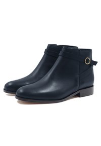 Navyblaue Leder-Stiefeletten mit einer glatten Oberfläche, ausgestattet mit einem seitlichen Riemen und einer runden Metall-Schnalle sowie einem niedrigen Blockabsatz.