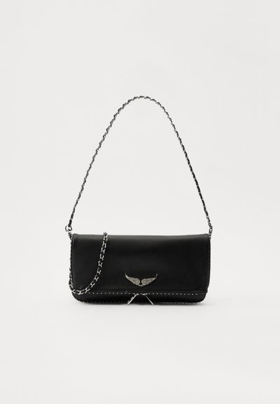 Sac à main en cuir noir avec une bandoulière en chaîne argentée, présentant des accents décoratifs en forme d'ailes et des coutures blanches le long de la couture inférieure.