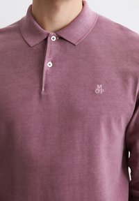 Fialové polo tričko z texturovanej bavlny, s klasickým golierom, dvomi gombíkmi a malým vyšitým logom na hrudi.